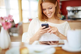 Woman sitting at a table viewing her phone